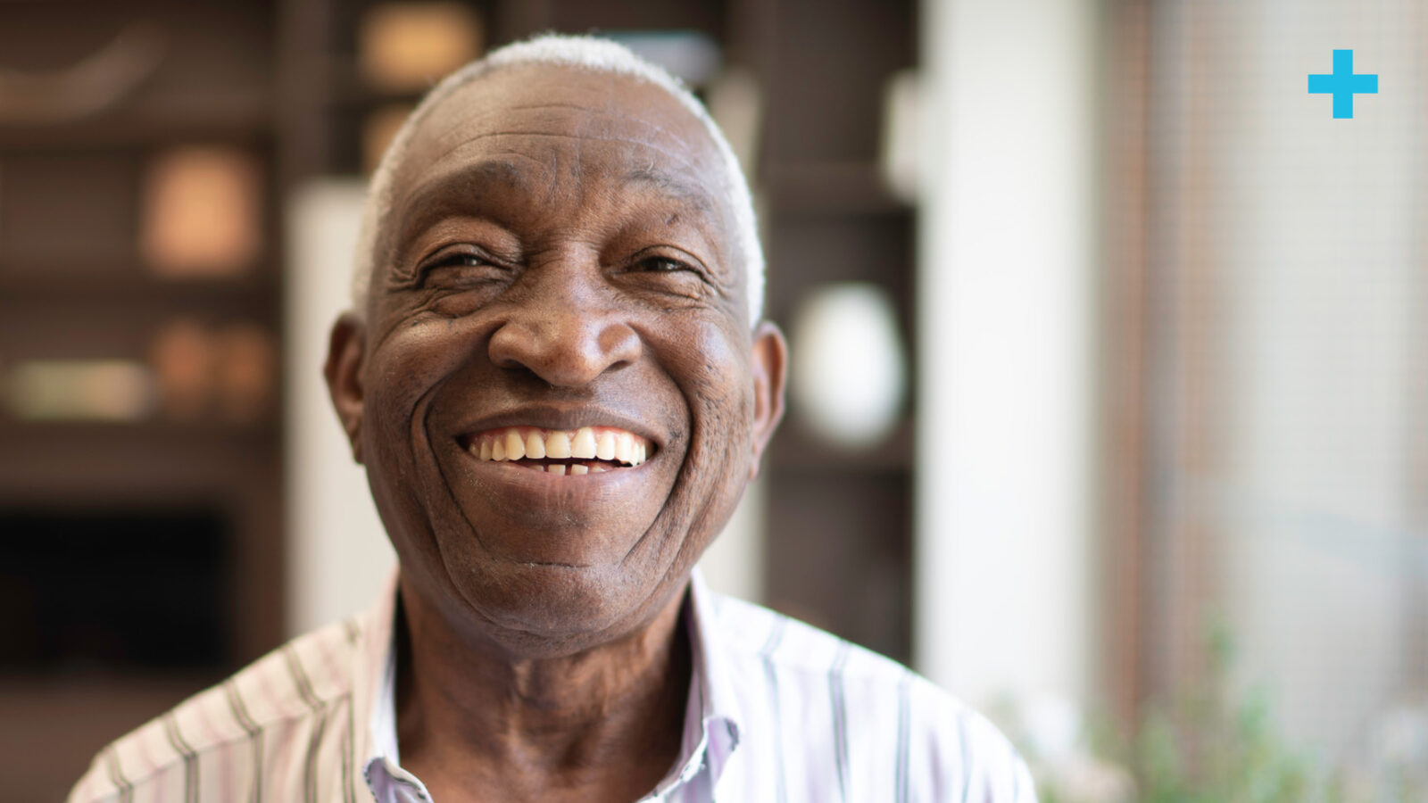 A older man looking at the camera with a big smile on his face.